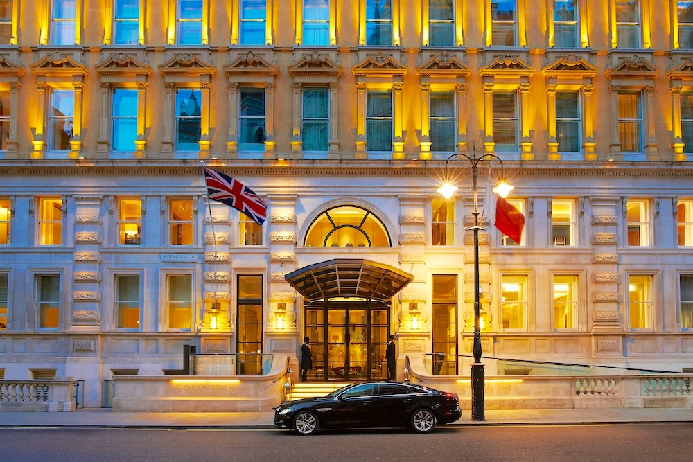Exterior view of Corinthia London Hotel in Whitehall with illuminated Victorian façade and entrance at dusk