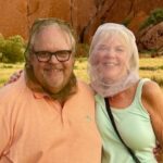 David and Carol Porter at Uluru wearing mosquito head nets during a visit to Australia's Red Center after a rare rainstorm.