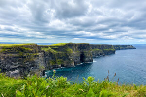 The Cliffs of Moher rise dramatically above the Atlantic Ocean along Ireland's rugged west coast on a windy summer day.