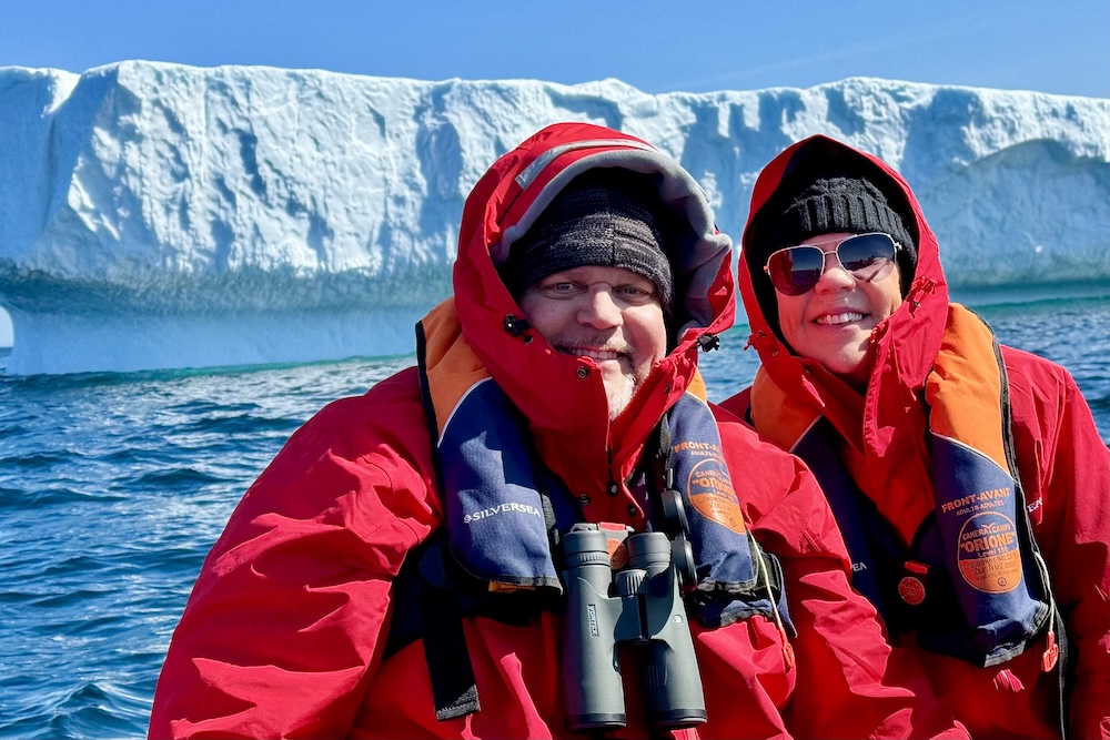 David and Carol Porter aboard a Silversea Expeditions Zodiac in front of a towering iceberg in the Davis Strait between Greenland and Canada's Baffin Island.