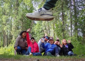 Our Tauck Bridges group reacts as Bigfoot appears to step over us during a fun scavenger hunt in the Talkeetna area of Alaska.