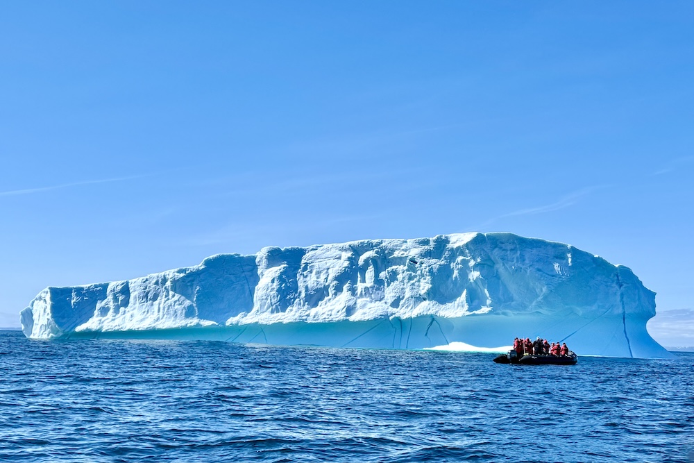 A Zodiac from a Silversea Expeditions voyage approaches a giant iceberg in the Davis Strait between Greenland and Canada's Baffin Island.
