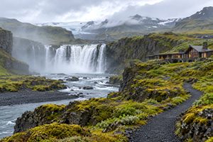 Waterfall and moss-covered volcanic cliffs in Iceland, one of 2027’s rising luxury travel destinations.
